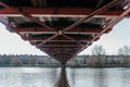 Under the Bridge: Architectural Perspective of Ironwork Over River Royalty Free Stock Photo