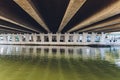 Under the bridge. The rhythm of the concrete pillars of the bridge leaving in perspective in the center of the far point