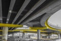 Under a concrete road bridge with yellow pillars