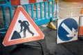 Under construction board sign on the closed road with arrow sign and traffic cone.