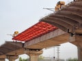 under construction bridge with red supports placed for metro train tracks, expressway to help solve traffic problem of