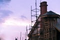 Under construction building with sloping roof, chimney and a tow