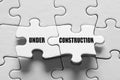 Under construction message on connected jigsaw puzzle pieces. Site construction or maintenance Royalty Free Stock Photo