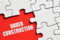 Under construction message surrounded by puzzle pieces. Website construction or maintenance Royalty Free Stock Photo