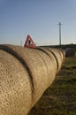 Under construction roadsign over straw round bales