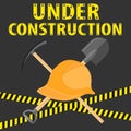 Under construction, site for construction. A construction helmet, a shovel and a pickaxe on a black background with a prohibiting Royalty Free Stock Photo