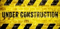 Under construction warning sign with yellow and black stripes on brick wall texture background in wide panorama format