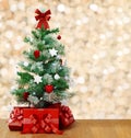 Under the decorated Christmas tree are red boxes with gifts. Tree on the background of lights in blur Royalty Free Stock Photo