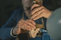 Under focused lighting in Cremona, a violin maker uses a vertical chisel to define the scroll. The scroll, blue vise, and gloved Royalty Free Stock Photo
