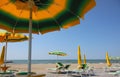 under a large yellow-green umbrella and open deck chairs on the Royalty Free Stock Photo