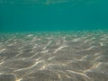 Under the Mediterranean Sea, under the crystal green waters, underwater a sandy beach, reflection of sunlight under the sea, under Royalty Free Stock Photo
