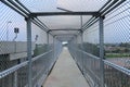 Under Metal mesh on steel walkways or Caged in walk way over passing highway and railway