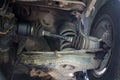 Under old car rear wheel axle dirty fix repair in garage. Vehicle shaft axle of power transmission to wheel of car. Royalty Free Stock Photo