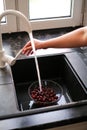 Young woman washing cherries at home Royalty Free Stock Photo