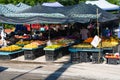 Under the sunlight, tents and fruit stalls.