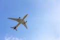 Under view of airplane for commercial passenger or cargo transporation flying on blue sky background with copy space Royalty Free Stock Photo