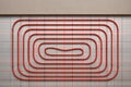 Underfloor heating installation with red piping on grid patterned surface for energy efficient home design concept of modern Royalty Free Stock Photo
