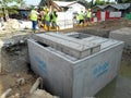 Underground drainage manhole under construction by construction workers at the construction site. Royalty Free Stock Photo