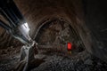 Underground metro construction. Man in the work with orange vest and hard hat on the rock slate and quartzite. Future Metro line