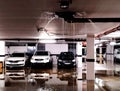 underground parking garage detail. storm rain water spewing from the drain pipe and flooding the concrete floor