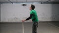 Underground parking. A young deft soccer man training football tricks. Balancing the ball on head and back.