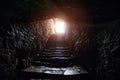 Underground passage under old medieval fortress. Old stone stairs to exit of tunnel Royalty Free Stock Photo