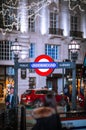 Underground sign and double decker. Festive decorations and Christmas lights at Piccadilly Circus. Royalty Free Stock Photo