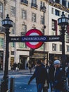 Underground sign subway entry way down stairs trains public transport lamps walk street road houses buildings London Royalty Free Stock Photo