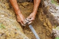 Man Working with Pipes in Ground while Installing a New Underground Sprinkler System Royalty Free Stock Photo