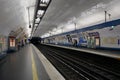 At an underground station of the French metro in Paris, several people are standing and waiting for a train Royalty Free Stock Photo