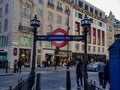 Underground subway picadelly circuis stairs down entry sign train street road shops historic buildings London city