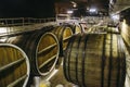 Underground wine cellar with old big wooden barrels or containers in winery Royalty Free Stock Photo