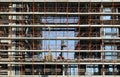 Underhook of tower crane suspended in the air in front of a large building under construction on background. Royalty Free Stock Photo