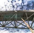 Underneath Sagamore bridge spans Cape Cod Canal under a sky mottled with a heavy cloud cover