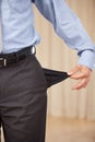 Underpaid. A cropped image of a businessman turning out his pocket and showing that it is empty. Royalty Free Stock Photo