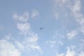 Underside view of a Helicopter in flight under thin layer of white clouds under blue sky Royalty Free Stock Photo