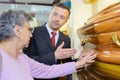 Undertaker showing woman coffin Royalty Free Stock Photo