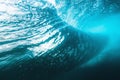 Underwater barrel wave in ocean and sun rays. Water texture in ocean