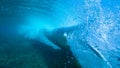 UNDERWATER: Beautiful deep blue tube wave rolls over the submerged camera. Royalty Free Stock Photo