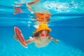 Underwater boy hold watermelon in the swimming pool. Cute kid boy swimming in pool under water. Royalty Free Stock Photo