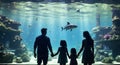 Underwater family. Silhouettes of young family of three enjoying views of underwater life. Family having free time in Oceanarium.