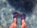 Underwater. Female legs in flippers in the blue-turquoise crystal clear water of the Antisamos beach, Sami Kefalonia island,