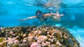 UNDERWATER: Female tourist snorkels around the colorful coral reef in Maldives.