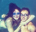 Underwater happy couple have an embrace in ocean or sea. Very soft focus