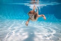 Underwater kid boy swim under water in swimming pool. Royalty Free Stock Photo