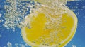 Underwater lemon slice in soda water or lemonade with bubbles