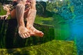 Underwater photo of child bare feet in natural swimming pool. Royalty Free Stock Photo