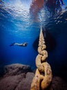 Underwater Photo of free diver girl with boat yacht chain in dark blue sea, Cyprus, ocean lover, snorkelling