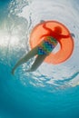 Underwater photo of girl swimming with fun on inflatable tube Royalty Free Stock Photo