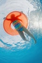 Underwater photo of girl swimming with fun on inflatable tube Royalty Free Stock Photo